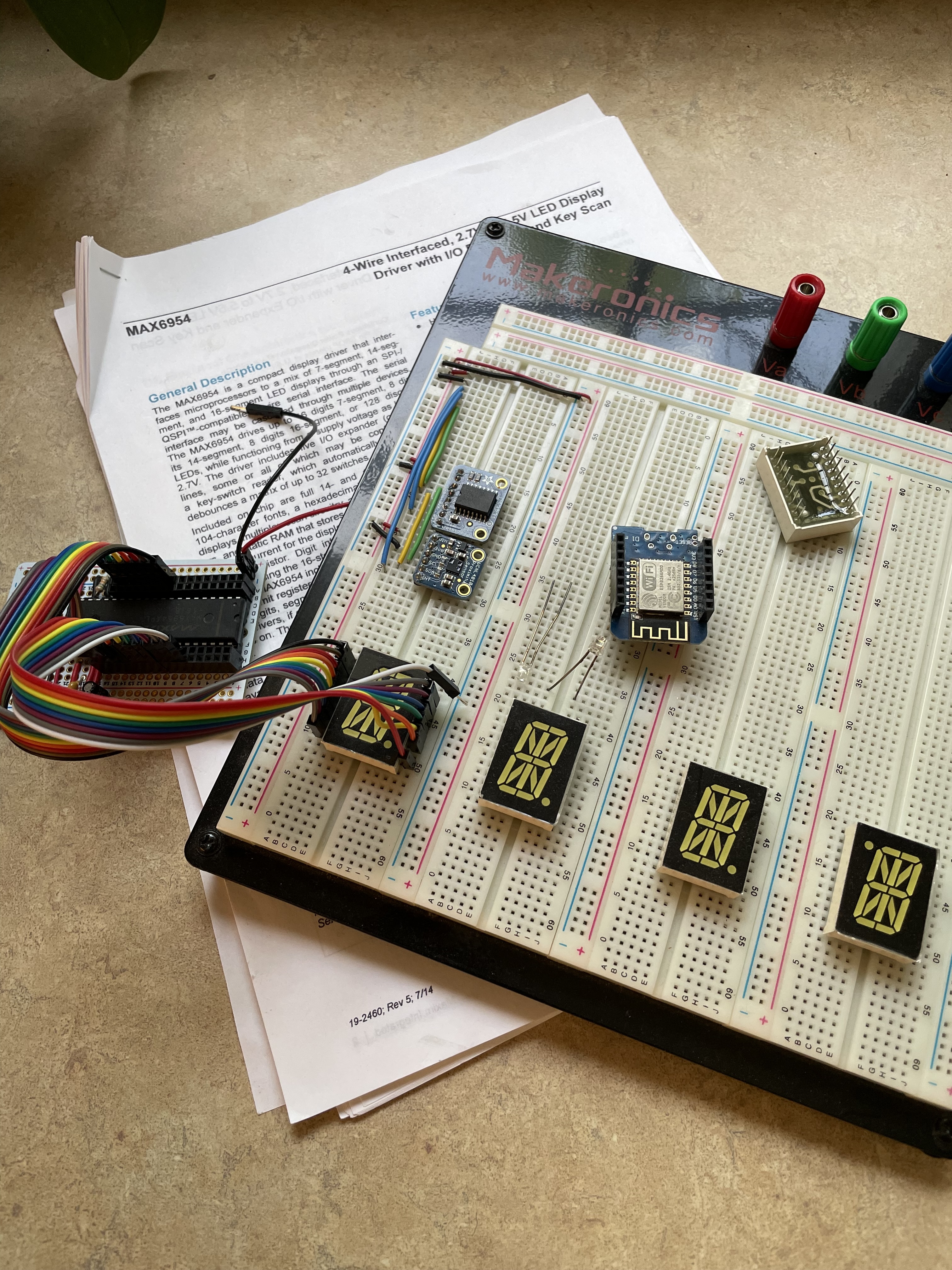A solderless breadboard showing several ICs and 14-segment displays.