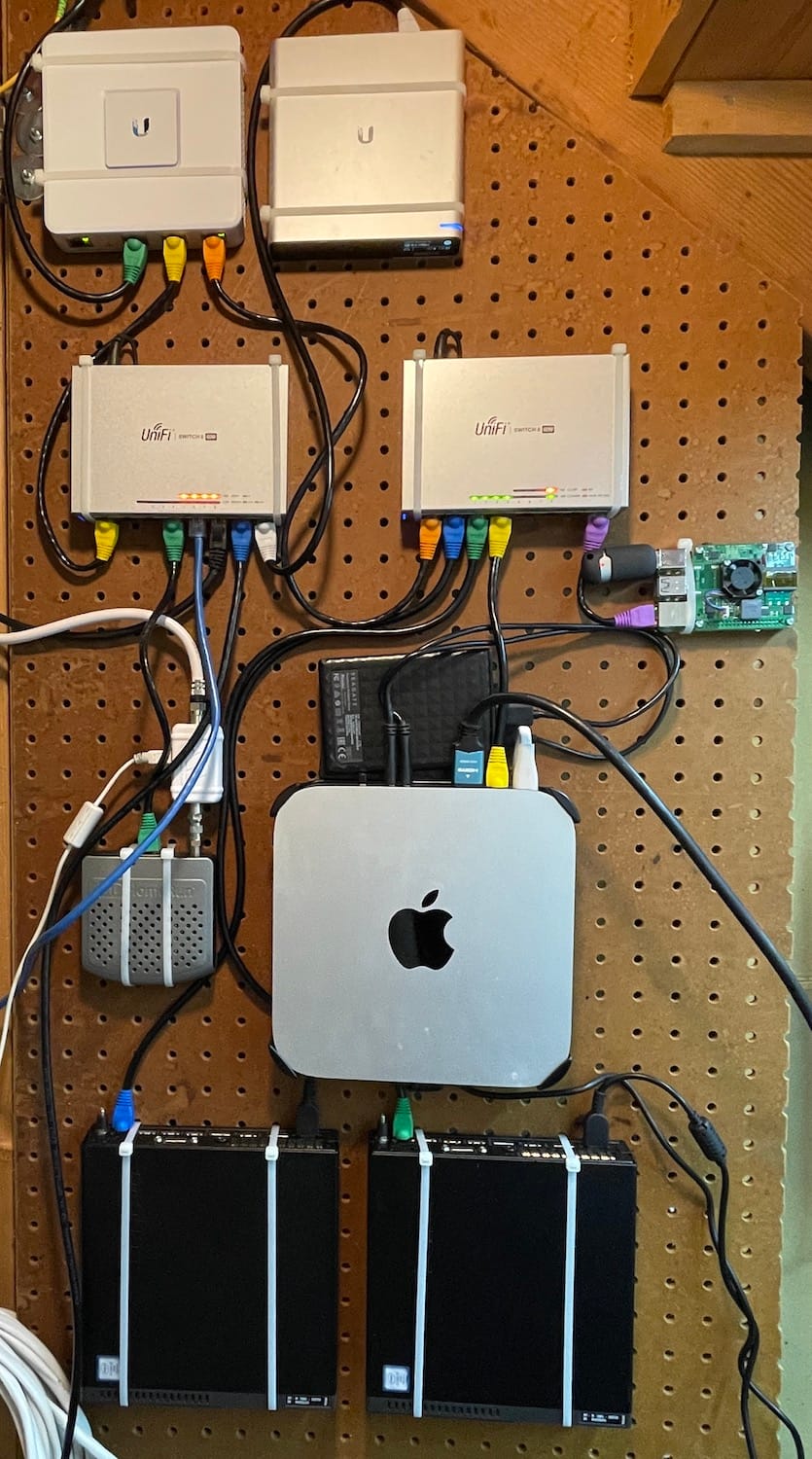 Pegboard with many computers and networking gear attached