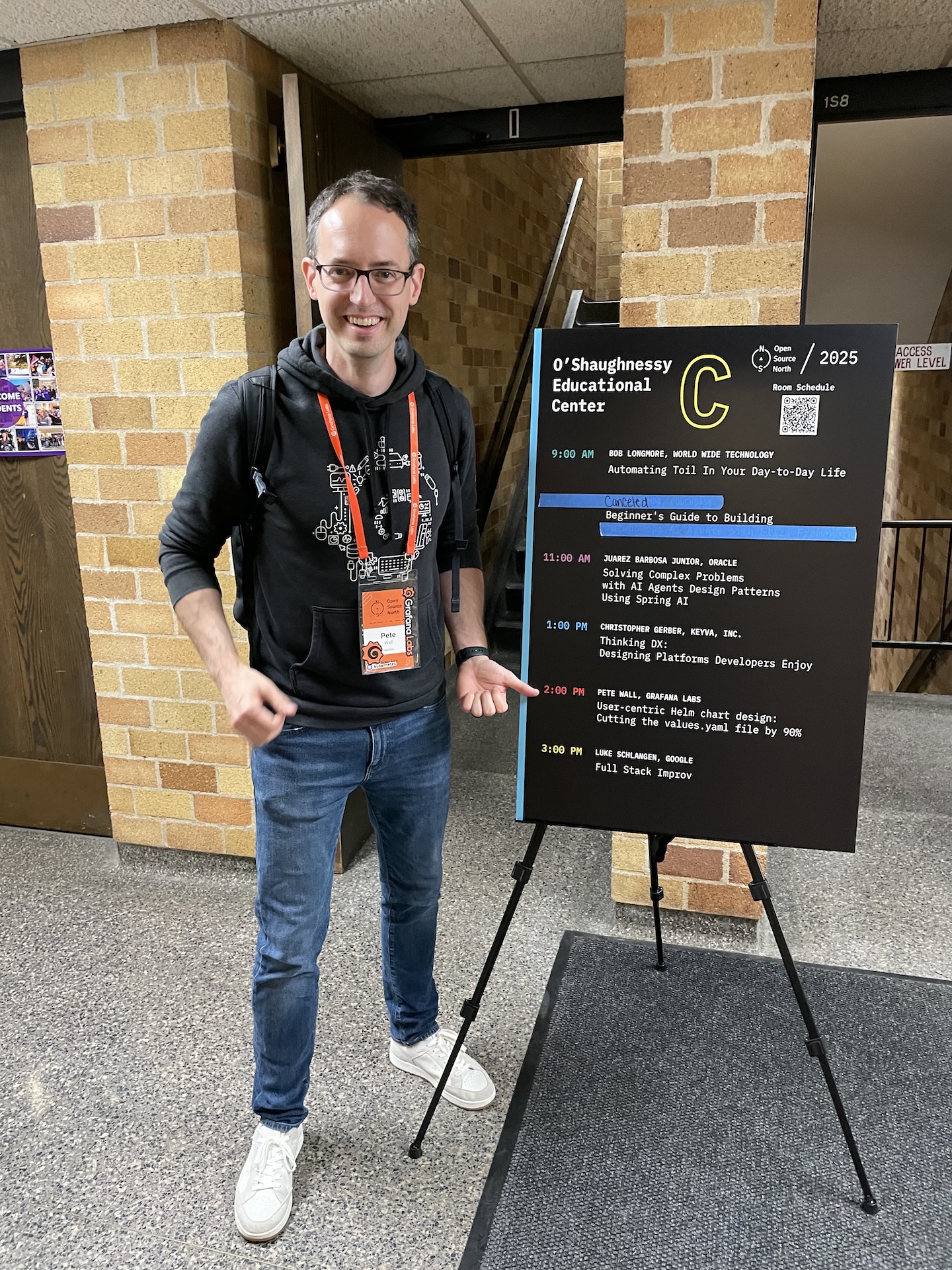 Pete next to the Open Source North 2025 schedule sign