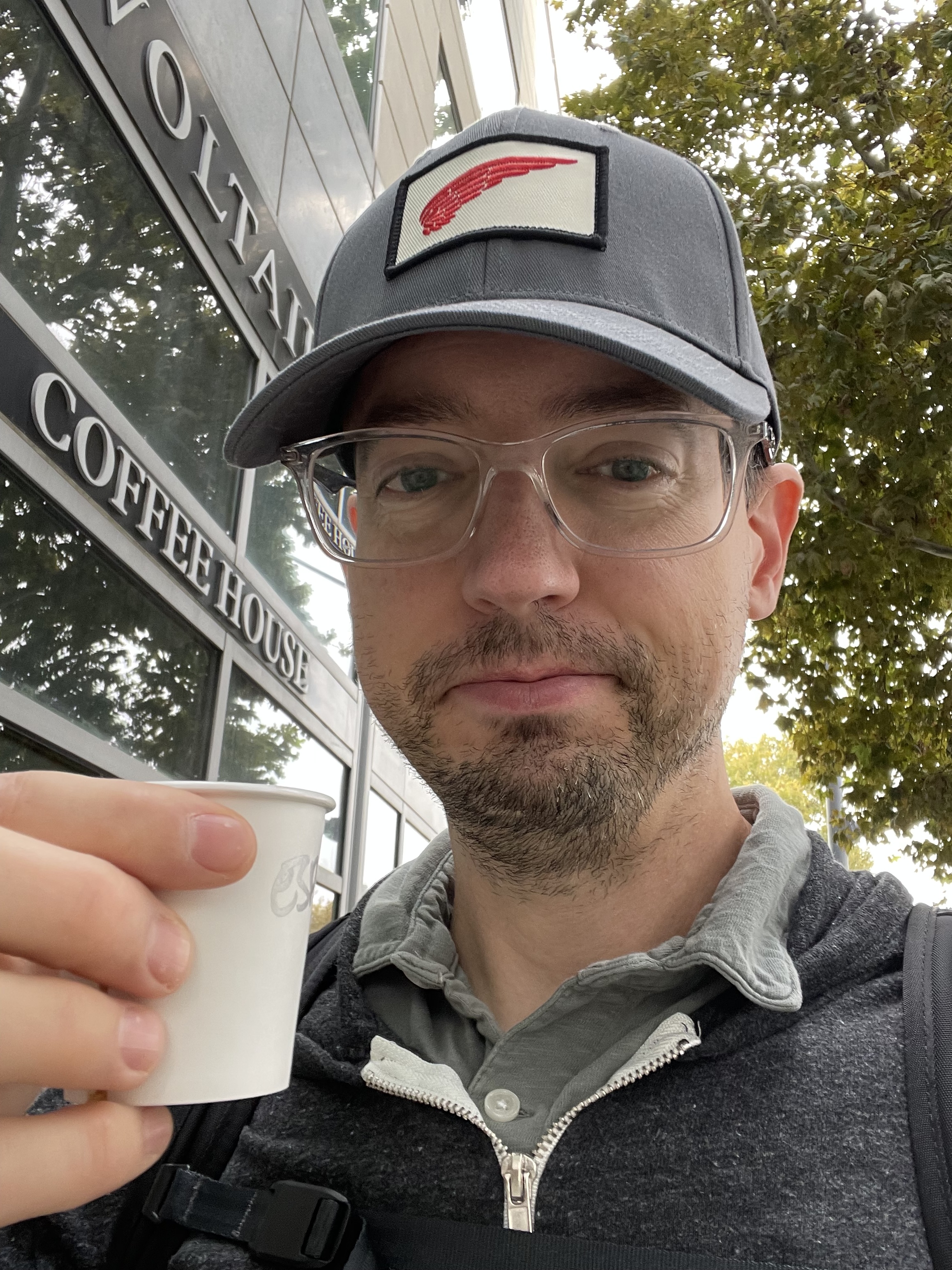 Pete holding a small cup of coffee.